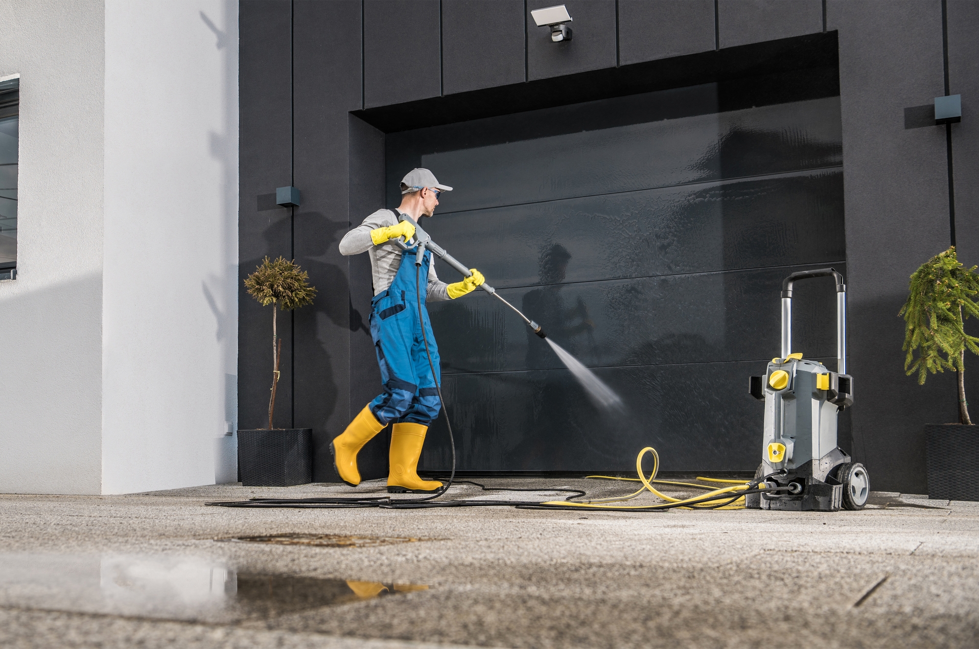 Worker Pressure Washing Garage Door